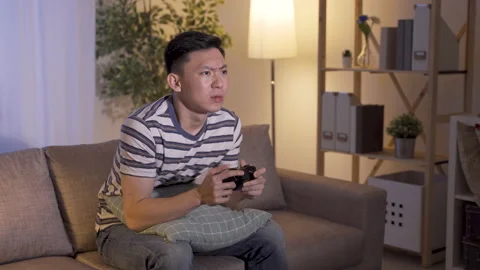 Man playing games picking up phone Stock Footage 136747752
