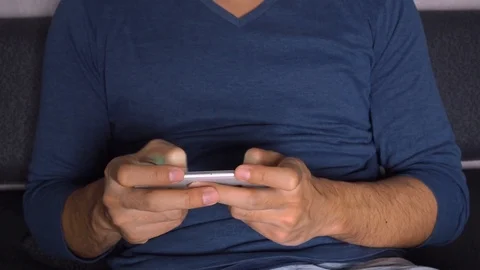 Man playing games on smart phone in dark room Stock Footage 88768532