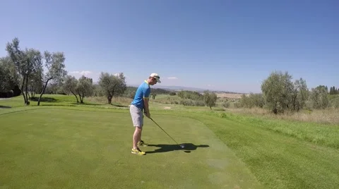 Man playing gold teeing off with driver on mountain course Tuscany Italy Stock Footage 61863375