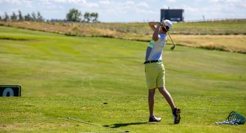 A man playing golf in the final position after hitting Stock Photos