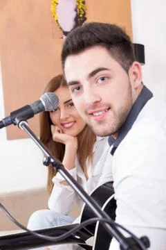Man playing guitar and singing to a cute girl Stock Photos