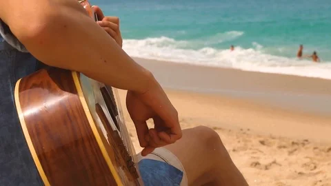 Man playing guitar on the beach, at sunset. Stock Footage 105372512