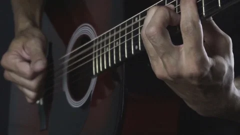 Man playing guitar on black background. Six strings. Playing with fingers Stock Footage 79019632