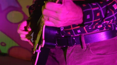 Man playing guitar in colourful lighting Stock Footage 112333079