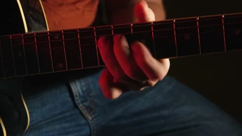 Man Playing Guitar with Neon Light. Musician Plays Music. Close Up Stock Footage 214757816