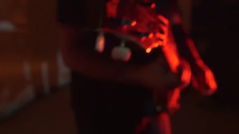 Man playing guitar in red stage lighting Stock Footage 112333066