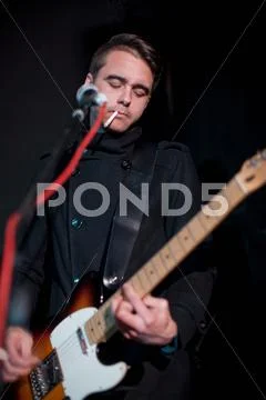 Man Playing Guitar On Stage In Club