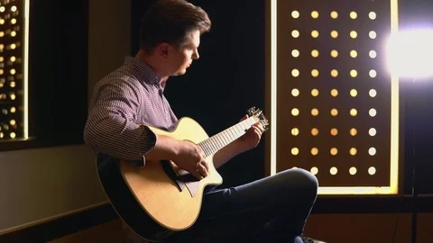 Man playing guitar in studio Stock Footage 104628756