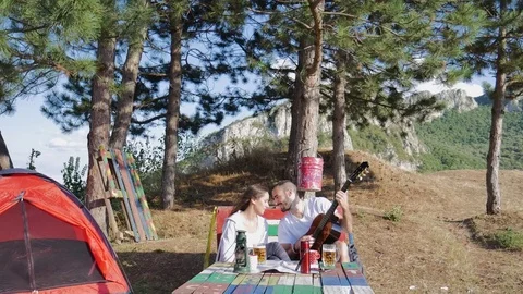 Man playing the guitar while his girlfriend is listening Stock Footage