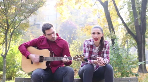 Man playing guitar while woman singing Stock Footage 59556773