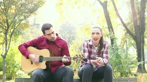 Man playing guitar while woman singing Stock Footage 59556776