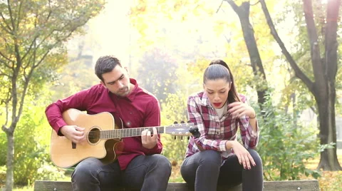 Man playing guitar while woman singing Stock Footage 59556790
