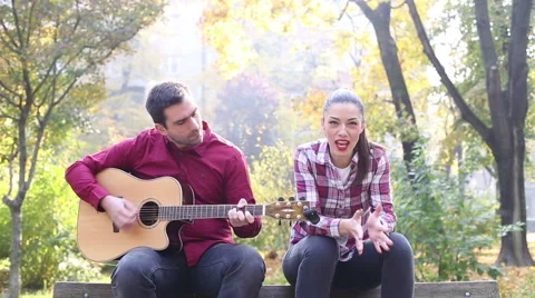 Man playing guitar while woman singing Stock Footage 59556796