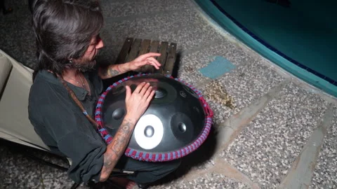 Man playing Handpan by pool - 24 Haziran 2026 fethiye muğla turkey Stock Footage 341529814