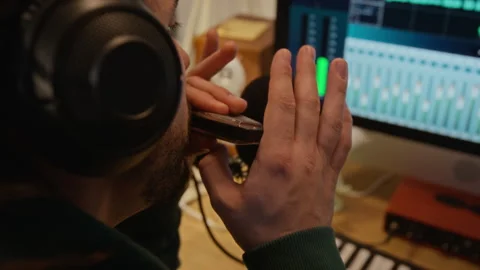 Man Playing Harmonica into Microphone in Home Recording Studio Vidéo 337509551