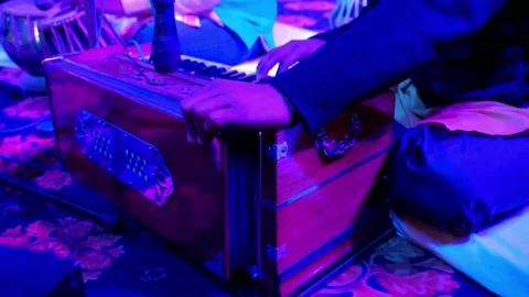 Man playing harmonium on stage giving performance at night Stock Footage
