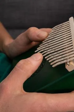 Man playing kalimba at home, exploring emotions with each note. Stock Photos