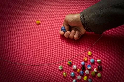 Man playing marbles Stock Photos