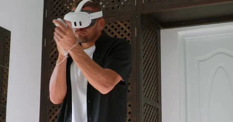 Man playing in new VR goggles or mixed reality with controllers. Stock Footage 254528840