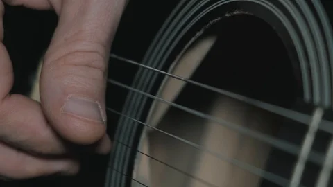 Man playing an old black acoustic guitar. Close-up. Slow-motion. Stock Footage
