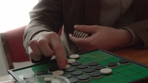 Man playing othello board game in cafe Stock Footage 132867972