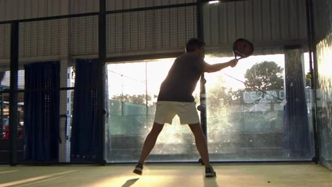 Man playing Padel hits the ball off the back wall bounce - slow motion Stock Footage 203834656