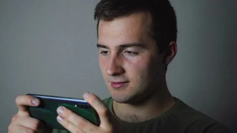 Man playing phone on gray background Stock Footage 142920860