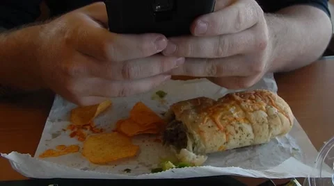 Man playing on phone instead of eating Vídeos de archivo 45314941