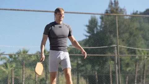 Man playing pickleball game, hitting pickleball yellow ball with paddle, outdoor Stock-Footage 229319365
