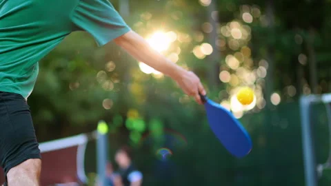 Man playing Pickleball, hitting the ball with a racket on an outdoor court. Slow Stock Footage 252723494
