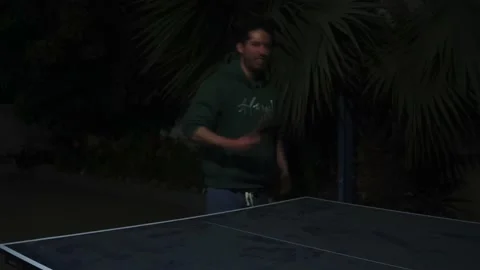 A man playing ping pong at night in a country house in 4k 库存影片 170019011