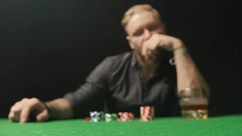 Man playing poker, doing a call with red chips towards camera. Stock Footage 125982780