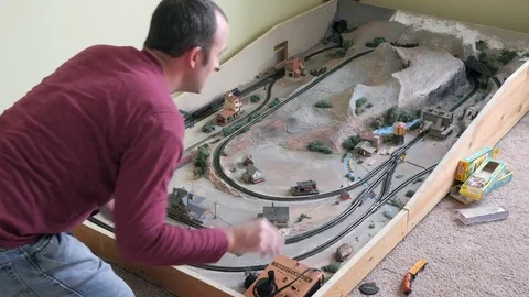 A man playing with a replica model train set he built Stock Footage 72194580