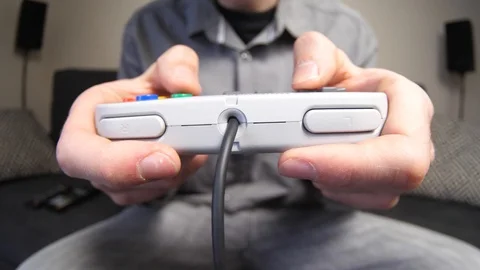 Man Playing With a Retro Gaming Controller in His Hands Stock Footage 89558692