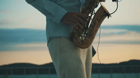 Man playing saxophone on sunset Stock Footage 86090490