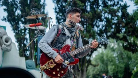 Man Playing Several Instruments at Once Performs in a Park Stock Photos