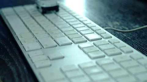 A man is playing a small white car on computer keyboard. Stock Footage 130477589