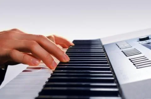 Man playing on a synthesizer, isolated on a gradient gray Stock Photos