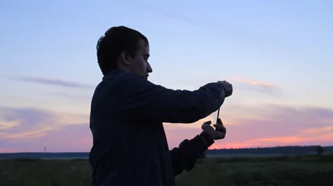 A man playing on a tablet in the game. Against the backdrop of a beautiful Video stock 64777316