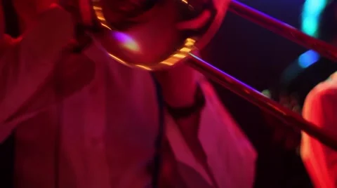 Man playing the trumpet during a performance, light from the colored spotlights Stock Footage 60697945