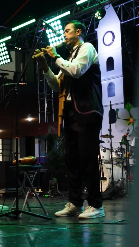 A man playing two musical instruments at a concert Stock Footage 313297423