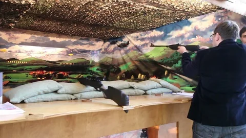 Man playing video arcade shooting rifle range game Stock Footage 80897841