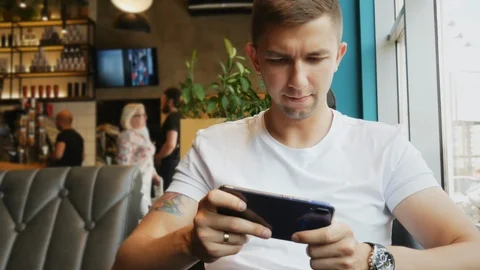 Man playing video game in cafe on the mobile phone, gadget or game addiction Video stock 110696225