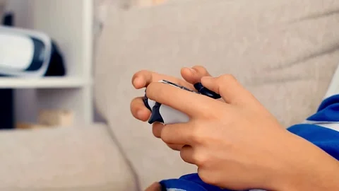A man playing a video game with a joystick. Close up of children's hands 库存影片 334653395