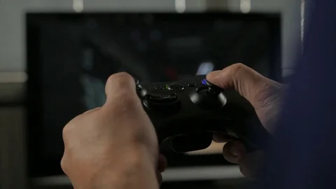 Man playing a video game using a game controller. With TV. Console Video Game. Video stock 69819367