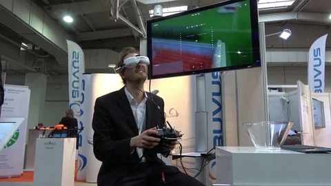 Man playing video game in virtual reality headset and handheld controllers on Stock Footage 74144892