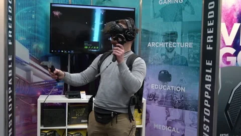 Man playing video game in virtual reality headset and handheld controllers Stock Footage 76328628