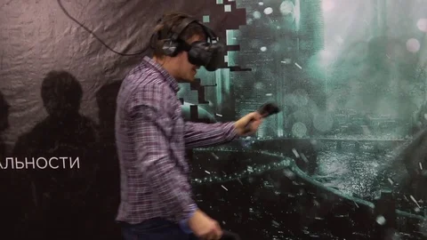 Man playing video game in virtual reality headset and handheld controllers Stock Footage 76870902