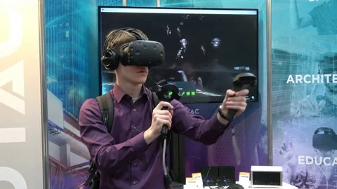 Man playing video game in virtual reality headset and handheld controllers Stock Footage 80991366