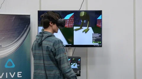Man playing video game in virtual reality headset and handheld controllers Stock Footage 80998984